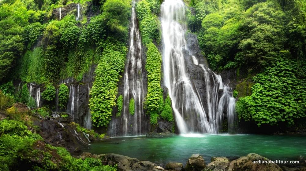 Traveler swimming at Banyumala Waterfall.jpg